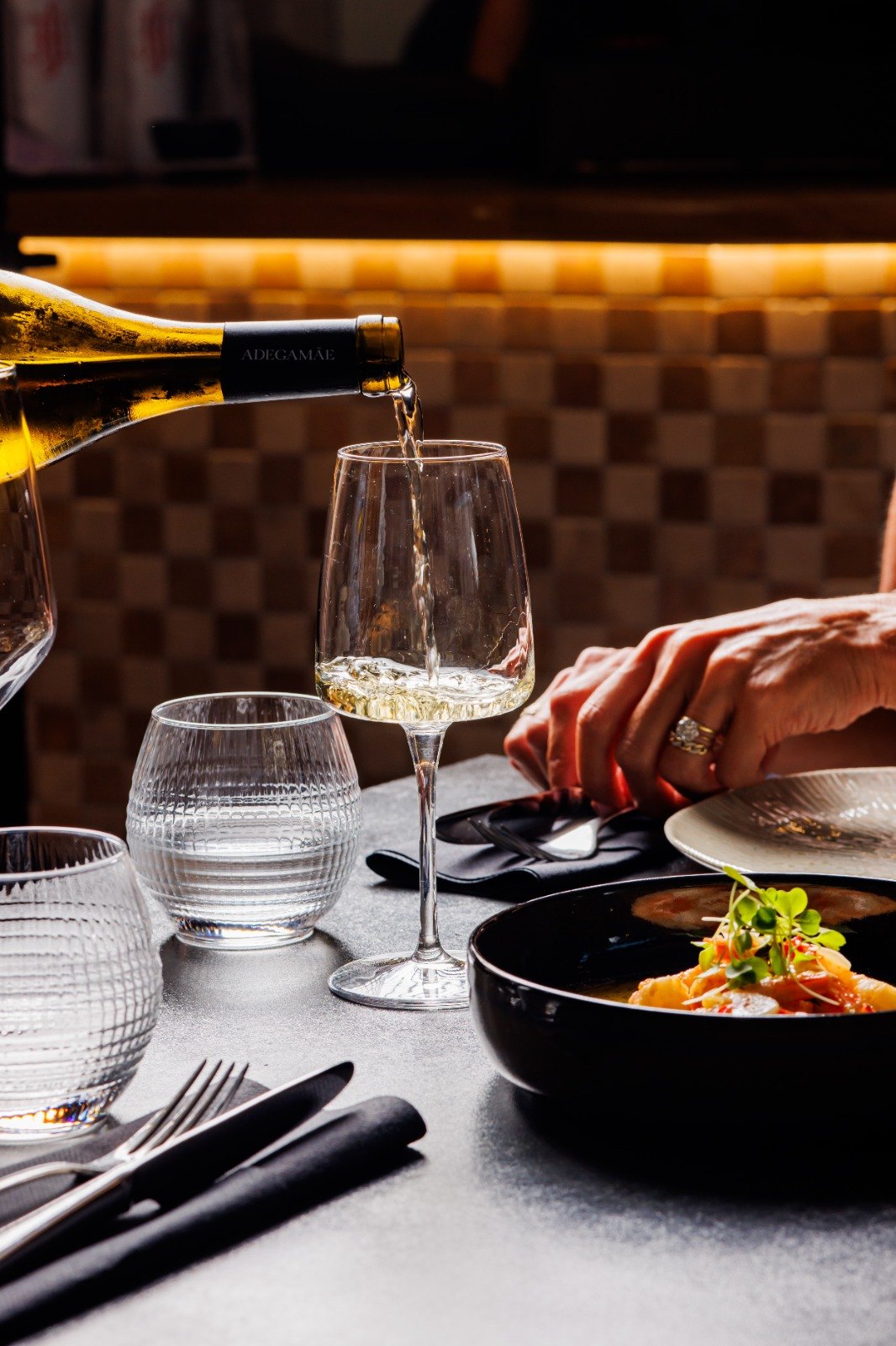 Vinho branco a ser servido à mesa no Per Se